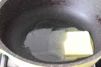 首先小火加热不粘锅，放入黄油融化成液态。
