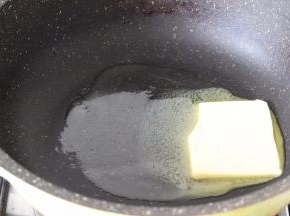 首先小火加热不粘锅，放入黄油融化成液态。