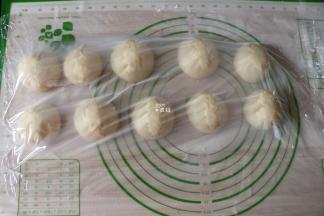 发酵好选择揉面程序揉面3-5分钟左右排气，然后分割成十等份一一揉圆，盖上保鲜膜静置松弛15分钟；