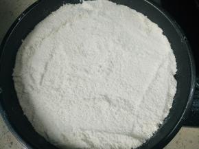 将一半粉类倒入铺了油纸的模具，用刮板刮平