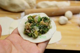 饺子皮拿在手心上，把饺子馅放入饺子皮里，馅料包好，饺子花纹很多，包自己喜欢的就行