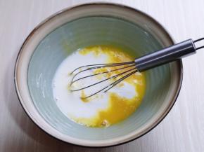 先做蛋黄糊，蛋黄用手动打蛋器打散，加入牛奶继续打均匀至看不到牛奶，加入玉米油，油和蛋液完全融合再一起。