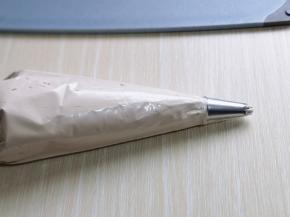 打发的奶油装入裱花袋中，如图。(记得先把裱花嘴放入裱花袋，再装奶油哈)