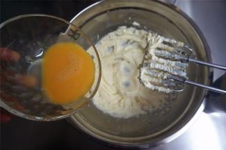 分两次加入全蛋液，每次都待搅打融合后再添加下一次，搅打至黄油蓬松发白。