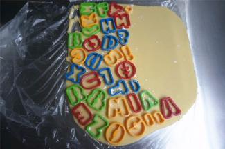 切开保鲜袋，饼干模拓上低筋粉后，印在面片上。将印出的饼干胚转移到烤盘上。