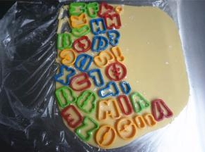 切开保鲜袋，饼干模拓上低筋粉后，印在面片上。将印出的饼干胚转移到烤盘上。