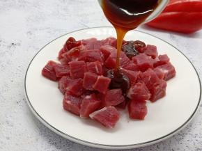 蚝油均匀地淋在牛肉粒上面。