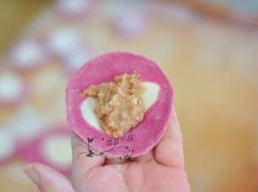 将面剂擀成圆片，中间放上馅。