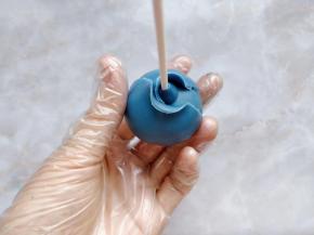 把一块翻糖皮擀成一大张圆形薄片，分成两个半圆，环绕着花心包在上面。