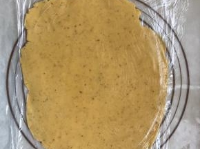 .4取出面团盖上保鲜膜，擀成薄饼。