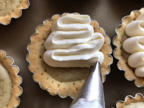 17.将装饰中的淡奶油和细砂糖打至8分发，裱花袋中装入裱花123号裱花嘴，装入奶油，挤在塔派上。