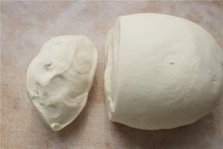 面板上撒干粉，把面团在案板上揉圆，揉好的面团切开后组织很细腻，这样擀皮的时候就会擀的更薄一些，也不会缩。