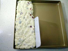 倒进金盘，等牛轧糖不烫手时，带上手套搓成圆柱形，用手按压整形。