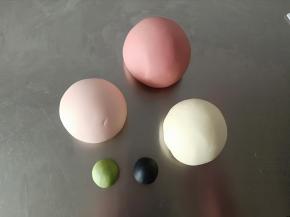 分别揉出140克红色面团，87克粉色面团，3克绿色面团，2克黑色面团，剩余的白面团备用