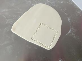 白色面片用模具压型，没有模具的切一个正方形，边缘用刮板压出水波纹