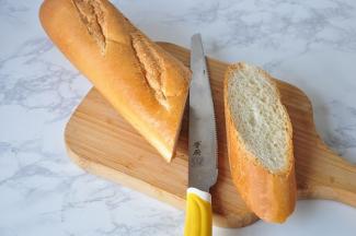 将法棍面包斜切大段。切面的大小要比飞鱼籽肠再略长一点。