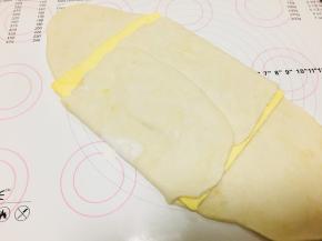 6、将黄油片放置于面团上，将四个边向内折叠包裹住黄油片