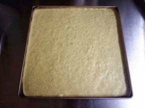 烤盘垫上不粘油布，将蛋糕糊倒入烤盘，震荡出大气泡。