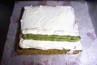 夹馅：将蛋糕体毛巾面朝上，抹上一层甜奶油，近端的甜奶油抹厚点，然后挤上抹茶奶油，再盖上甜奶油。