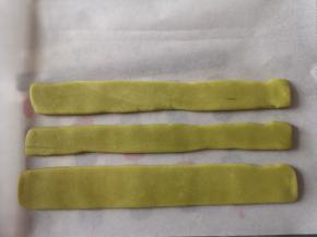 把浅色抹茶面团分成三份，三份面团滚圆，搓成一样长度压扁，大概一毫米到两毫米厚，放冰箱冷冻十分钟。