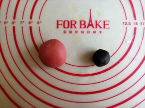 取7克白面团加入食用竹炭粉和成黑色面团，25克白面团加入红曲粉和成红色面团