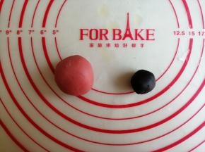 取7克白面团加入食用竹炭粉和成黑色面团，25克白面团加入红曲粉和成红色面团