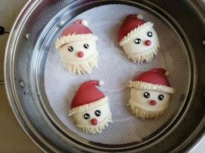 将做好的圣诞老人馒头放在蒸屉里，在温暖处醒发，可以看到馒头胚明显变大一点