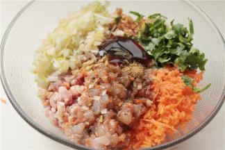 揉面的时候做馅，胡萝卜切成末，大虾剥去虾壳，去虾线切成粒，葱姜和香菜也切末。全部馅料的食材和调料都放在一起。