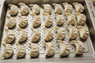 包好的蒸饺排排放在蒸盘里。