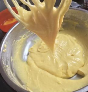 将面团盛入盆中，提前打散三个鸡蛋，分三次倒入盆中，用刮刀每次翻拌至吸收后再加入下一次，打散第四个鸡蛋，一点点加入，搅拌面糊至光滑细腻，观察粘稠度，至提起后呈倒三角即可。