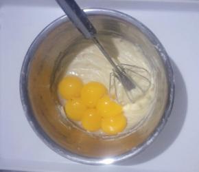 把蛋黄蛋清分离，蛋清放入另一无水无油的盆中。把蛋黄放入刚搅拌好的面糊中