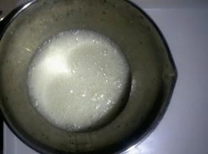 加入三分之一的糖，用手持电动打蛋器中低速打发至蛋清呈鱼眼泡状