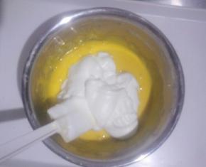 取三分之一蛋白放入蛋黄糊中，用刮刀翻拌均匀(不可画圈搅拌)