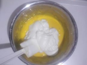 取三分之一蛋白放入蛋黄糊中，用刮刀翻拌均匀(不可画圈搅拌)