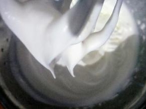 用手持电动打蛋器中低速打发至奶油出现明显花纹，打蛋器提起奶油呈小弯尖状态即可