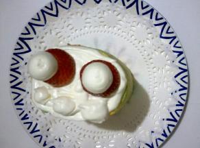 放上草莓底，用淡奶油挤两个圆球如图