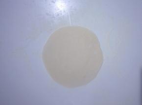 取一个小面团，揉圆按扁擀成中间厚周边薄的面皮儿