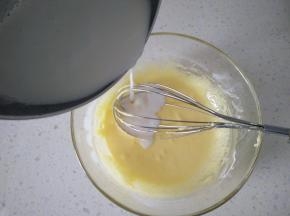 3牛奶加热倒入蛋黄液里，一边倒入一边不停搅拌。