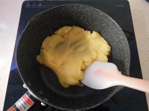 9再次放在炉灶上小火加热，用刮刀不断压拌翻炒，使面糊变得干燥蒸发水分，离火。