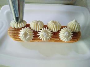 19在泡芙顶部挤上奶油，摆上草莓即可。