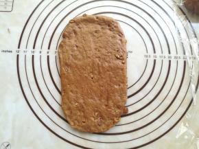 取一个面团擀成长的牛舌状，光滑面朝下