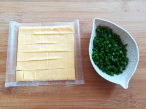 把一片芝士片切成50片以上的小块，葱花切小段