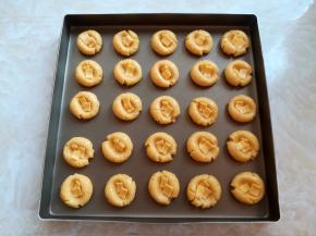 用大拇指把芝士小圆球中间按一个深的坑，刷一层薄薄的蛋液，每一个坑里放入2片小芝士片