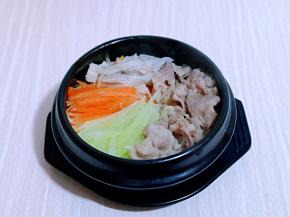 将蔬菜及肥牛摆放在米饭上面，如图。