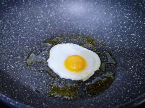 现在煎荷包蛋，锅中放入食用油，敲入鸡蛋，小火煎。