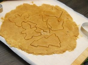 面团放入硅油纸上，用擀面杖擀开，然后用饼干模具刻出饼干胚，把多余的边角继续揉搓擀薄，刻出饼干胚