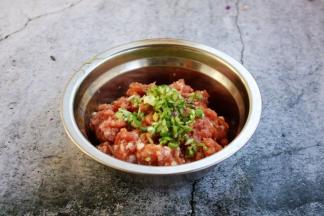 放入葱花，在葱花上滴入1小勺的食用油，用油将葱花拌匀，然后将葱花与肉馅搅拌均匀备用。