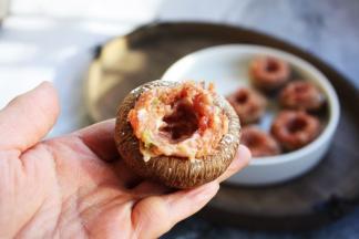 用筷子夹约13g左右的肉馅将香菇“杯子”填满，然后用筷子在中间挖一个洞眼，洞眼的大小和鹌鹑蛋大小差不多。