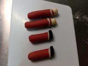 剩余红色面团搓成长条状，切出圣诞老人的腿和胳膊来，分别做好造型