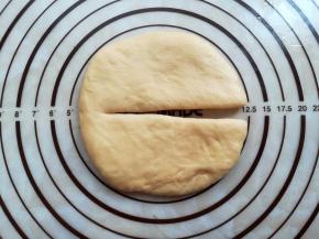 取一个90克的面团光滑面朝上，擀成12厘米直径大小，从中间切一刀不切断，其他面团分别擀成5-11cm，重量越大，直径越大，留15克的那个不擀圆。